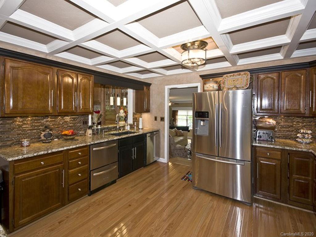 82 Gregg Roost Road Sylva, NC 28779 - Photo 33 of 35 a kitchen with stainless steel appliances granite countertop a stove a refrigerator a sink and dishwasher with wooden floor