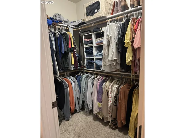 a view of walk in closet with clothes and shoes