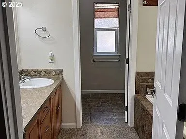 a bathroom with a granite countertop sink and a mirror