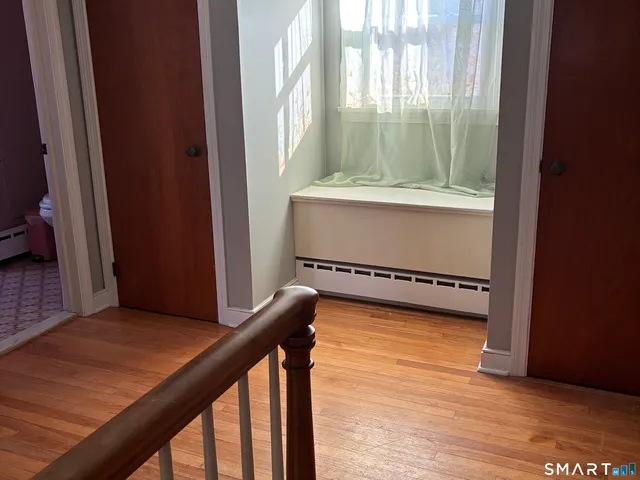 a view of a room with wooden floor and iron stairs