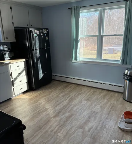 a view of a kitchen with refrigerator and window