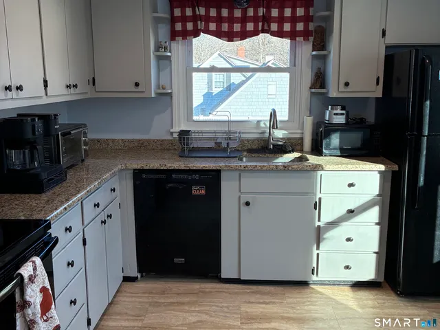 a kitchen with stainless steel appliances granite countertop a sink stove and cabinets