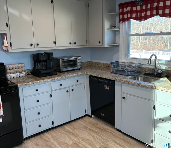 a kitchen with granite countertop white cabinets and sink