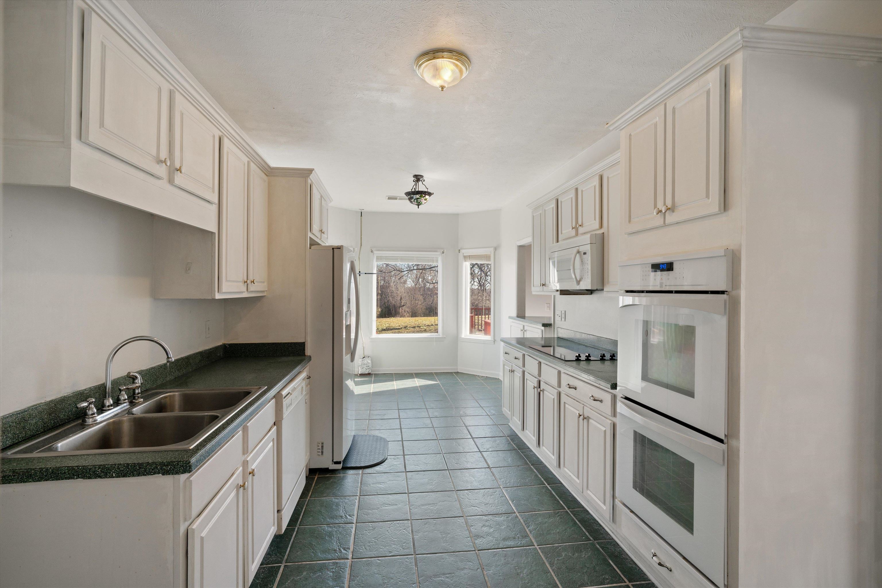 130 Belmont Road Mason, TN 38049 - Photo 8 of 24 Kitchen with white cabinetry, sink, and white appliances