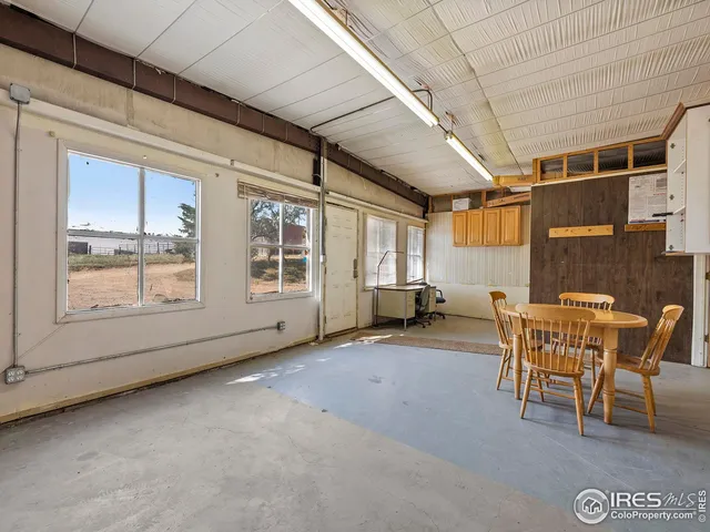 a view of a livingroom with furniture and next to a window