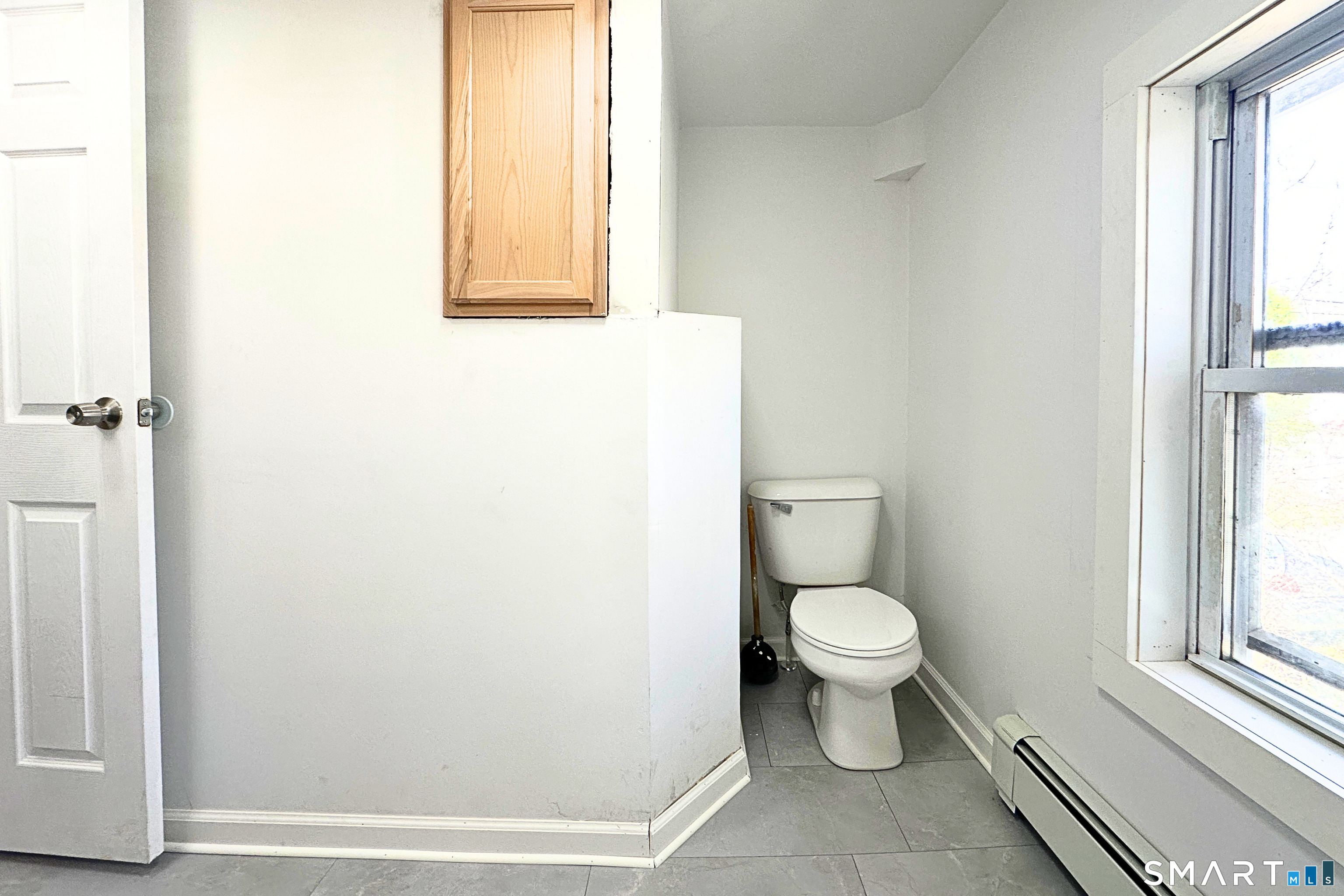 88 Taftville-Occum Road, Unit C Norwich, CT 06360 - Photo 19 of 28 a white toilet sitting in a bathroom next to a window