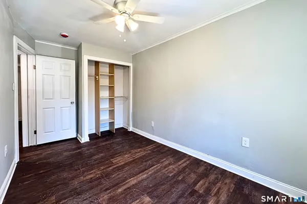 an empty room with wooden floor and entryway