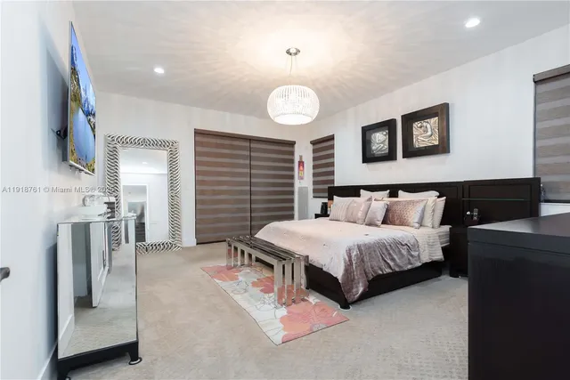 a spacious bedroom with a bed and a chandelier