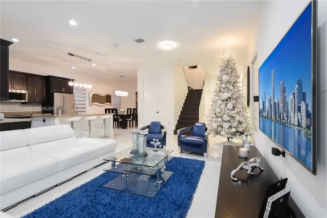 a living room with furniture wooden floor and a large window