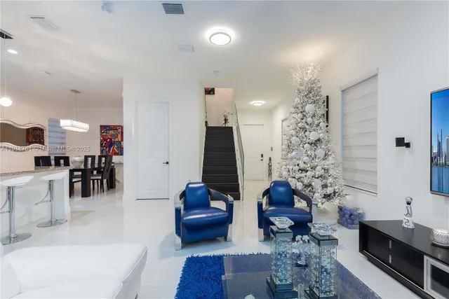a living room with furniture a chandelier and a rug