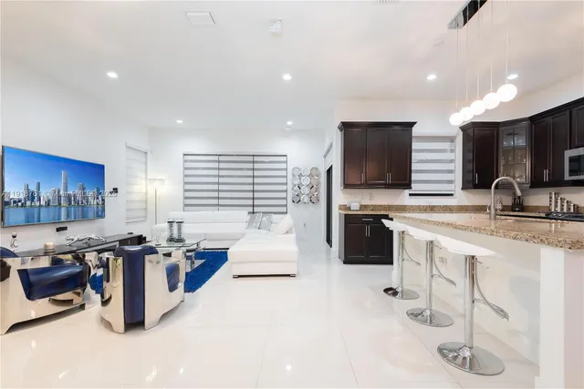 a large white kitchen with lots of counter space a sink and appliances