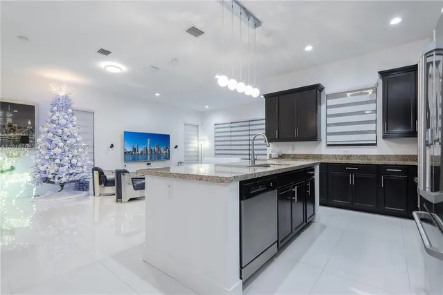 a kitchen with stainless steel appliances kitchen island granite countertop a stove top oven a sink dishwasher a dining table and chairs