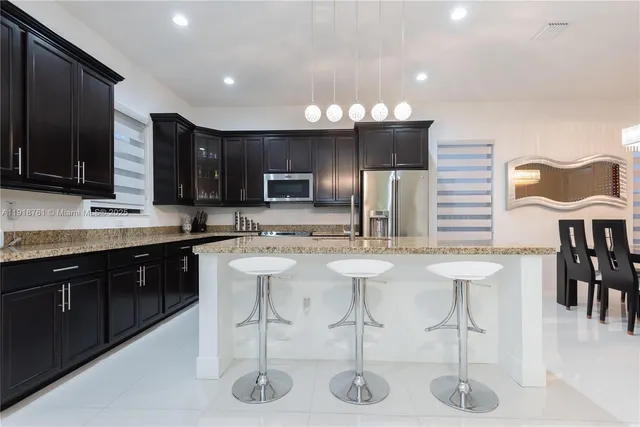 a kitchen with stainless steel appliances kitchen island granite countertop a sink and cabinets
