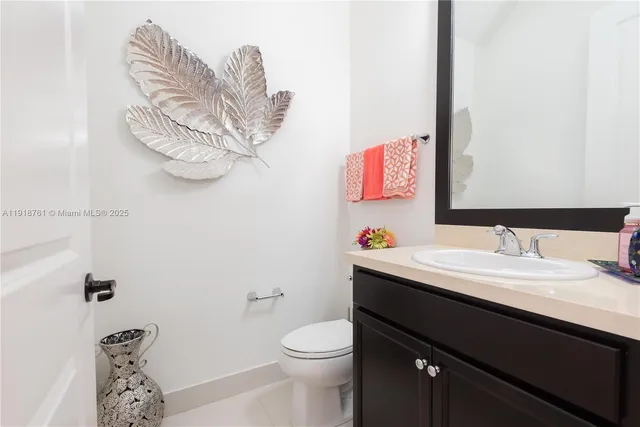 a bathroom with a sink vanity mirror and toilet