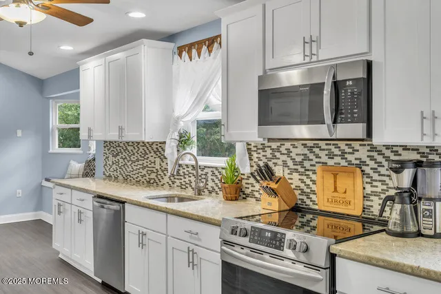 a kitchen with granite countertop a stove sink and cabinets