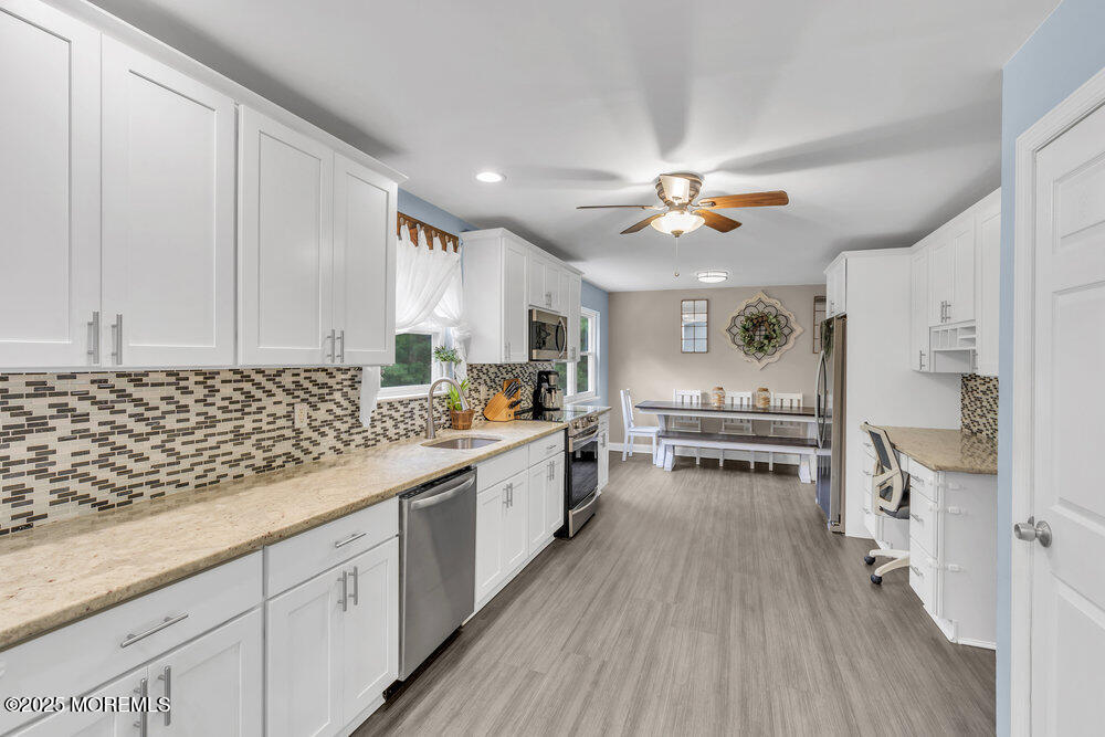 375 South Stump Tavern Road Jackson, NJ 08527 - Photo 8 of 34 a kitchen with stainless steel appliances a stove a sink and white cabinets with wooden floor