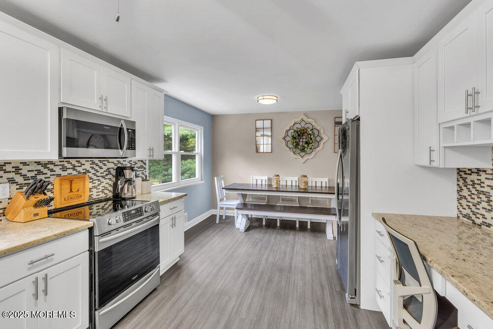 375 South Stump Tavern Road Jackson, NJ 08527 - Photo 10 of 34 a kitchen with stainless steel appliances granite countertop a stove top oven a sink dishwasher a dining table and chairs with wooden floor