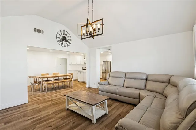 a large white kitchen with a large window a sink and stainless steel appliances