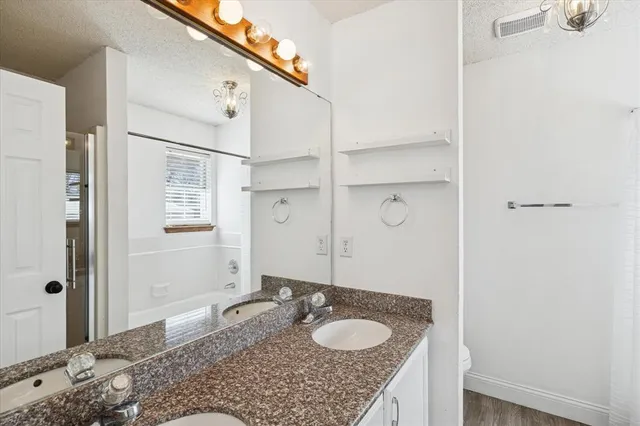 a bathroom with a granite countertop sink and a mirror