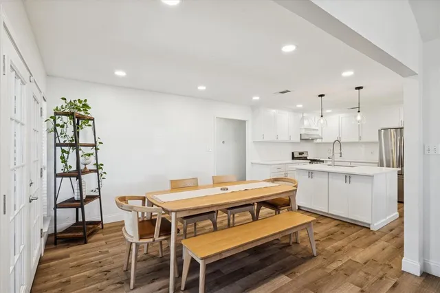 a kitchen with a table chairs sink and cabinets