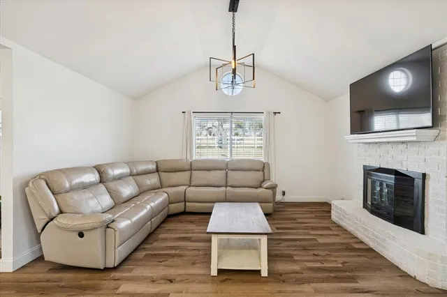 a living room with furniture a fireplace and a flat screen tv