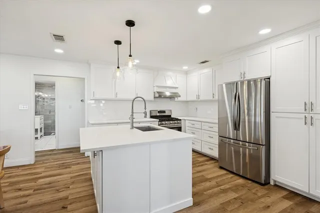 a kitchen with refrigerator cabinets and wooden floor