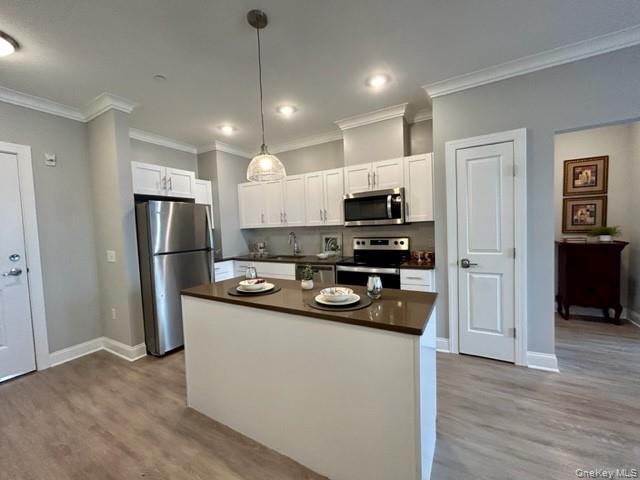 75 East Hoffman Avenue, Unit 2077 Lindenhurst, NY 11757 - Photo 7 of 15 a kitchen with stainless steel appliances granite countertop a refrigerator a stove a sink and a microwave