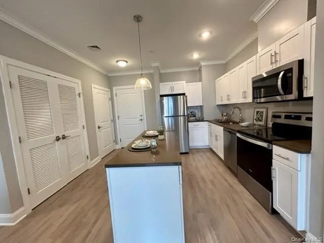 a kitchen with stainless steel appliances kitchen island granite countertop a stove a sink and a refrigerator