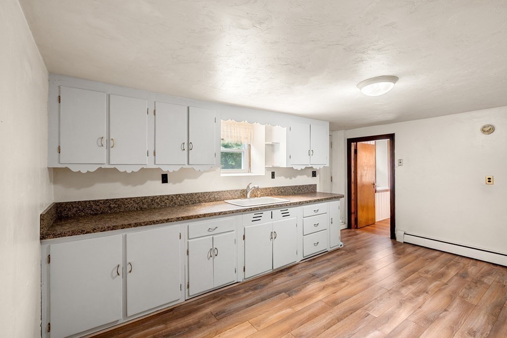 3 Wilson Street Worcester, MA 01604 - Photo 26 of 42 a large kitchen with granite countertop a sink and cabinets with wooden floor