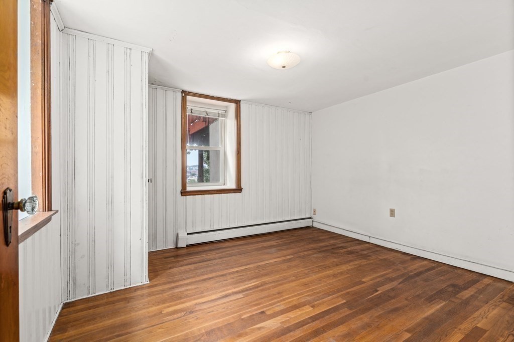 3 Wilson Street Worcester, MA 01604 - Photo 28 of 42 a view of an empty room with wooden floor and a window