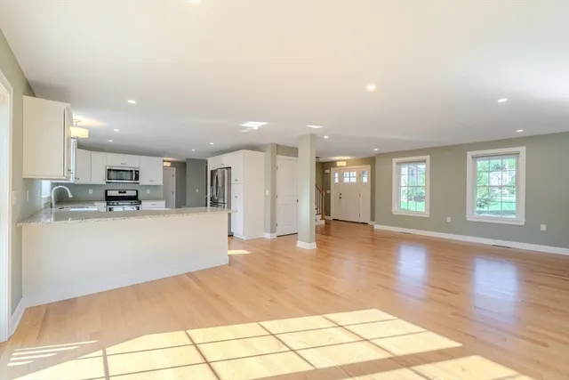 a view of a kitchen with kitchen island granite countertop a refrigerator and a stove top oven