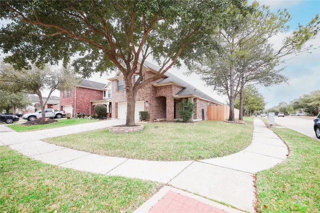 a front view of a house with a yard and trees