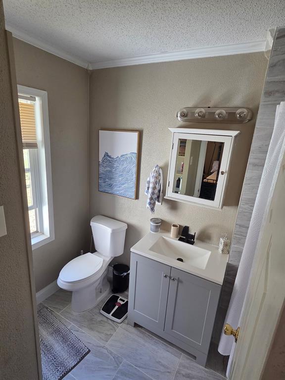 1145 Jefferson Road Paris, TX 75460 - Photo 4 of 14 a bathroom with a toilet a sink a mirror a window and vanity