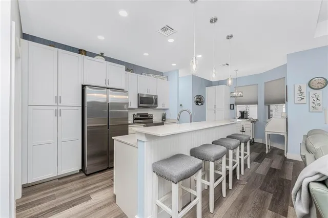 a kitchen with kitchen island a sink stainless steel appliances and cabinets