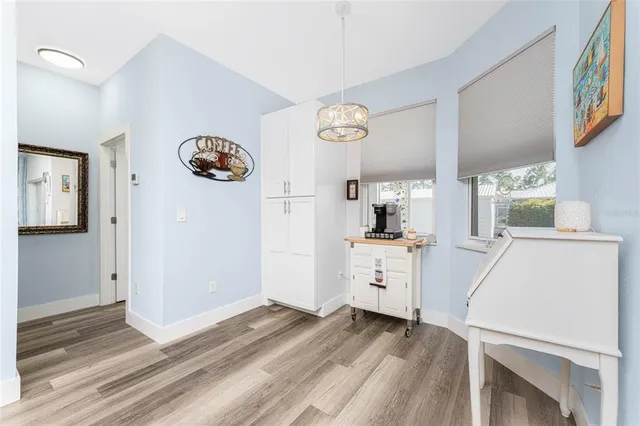 a bedroom with a bed and dresser with wooden floor
