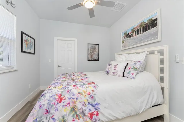 a living room with furniture a large window and wooden floor