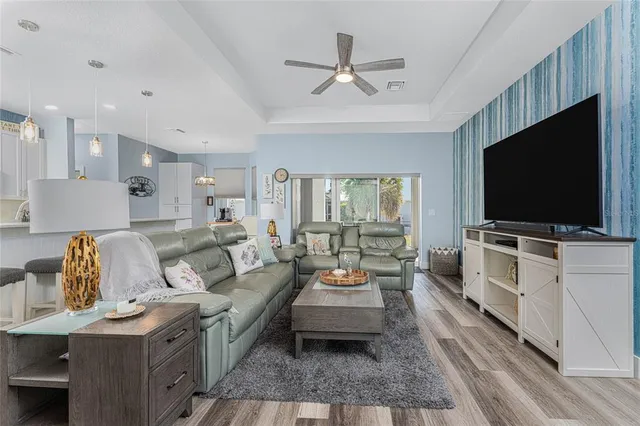 a living room with furniture kitchen view and a flat screen tv
