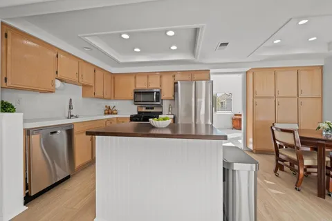 a kitchen with stainless steel appliances granite countertop a refrigerator and a stove top oven