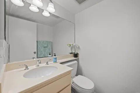 a bathroom with a sink a toilet and mirror