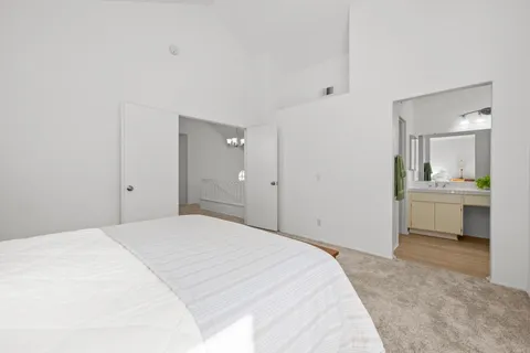 a spacious bedroom with a bed and a view of bathroom