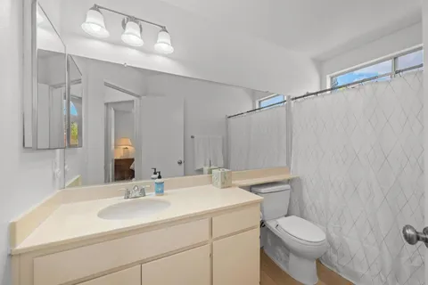 a bathroom with a sink toilet a mirror and shower