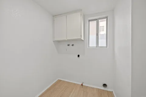 a view of small space with wooden floor and fan