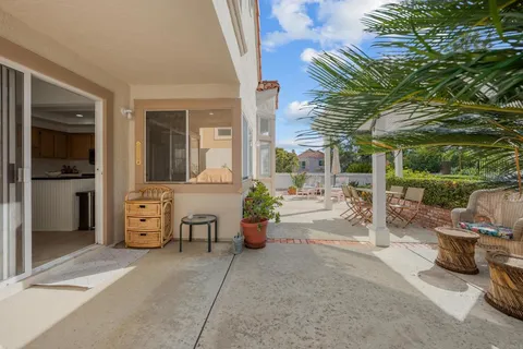a view of a patio with table and chairs potted plants