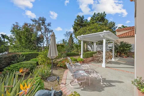 a view of a patio with couches table and chairs and garden