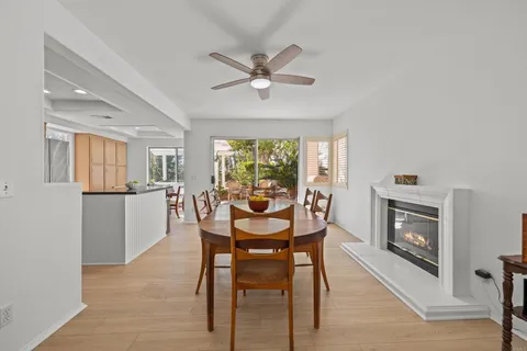 a dining room with furniture a fireplace and wooden floor