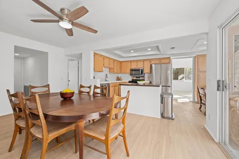 a kitchen with a dining table chairs and refrigerator