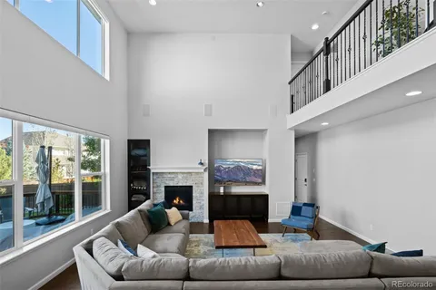 a living room with furniture a fireplace and a large window