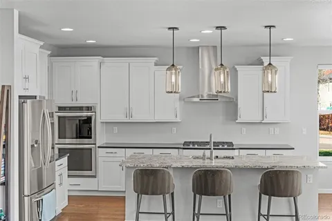 a kitchen with stainless steel appliances granite countertop a stove a sink and a refrigerator