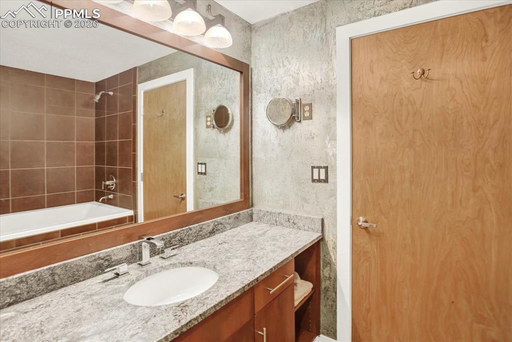 101 North Tejon Street, Unit 460 Colorado Springs, CO 80903 - Photo 25 of 49 a bathroom with a granite countertop sink and a mirror