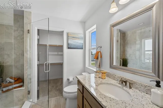 a bathroom with a granite countertop sink toilet and shower